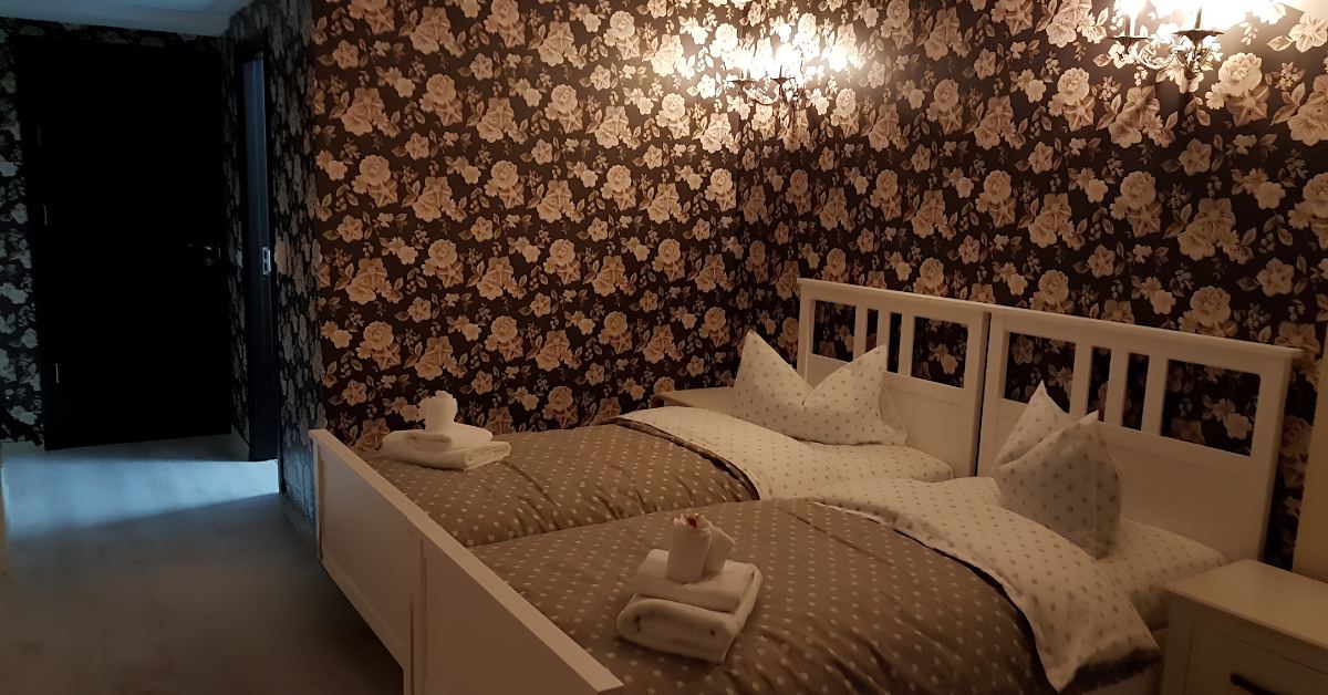 Twin room with decorative floral wallpaper